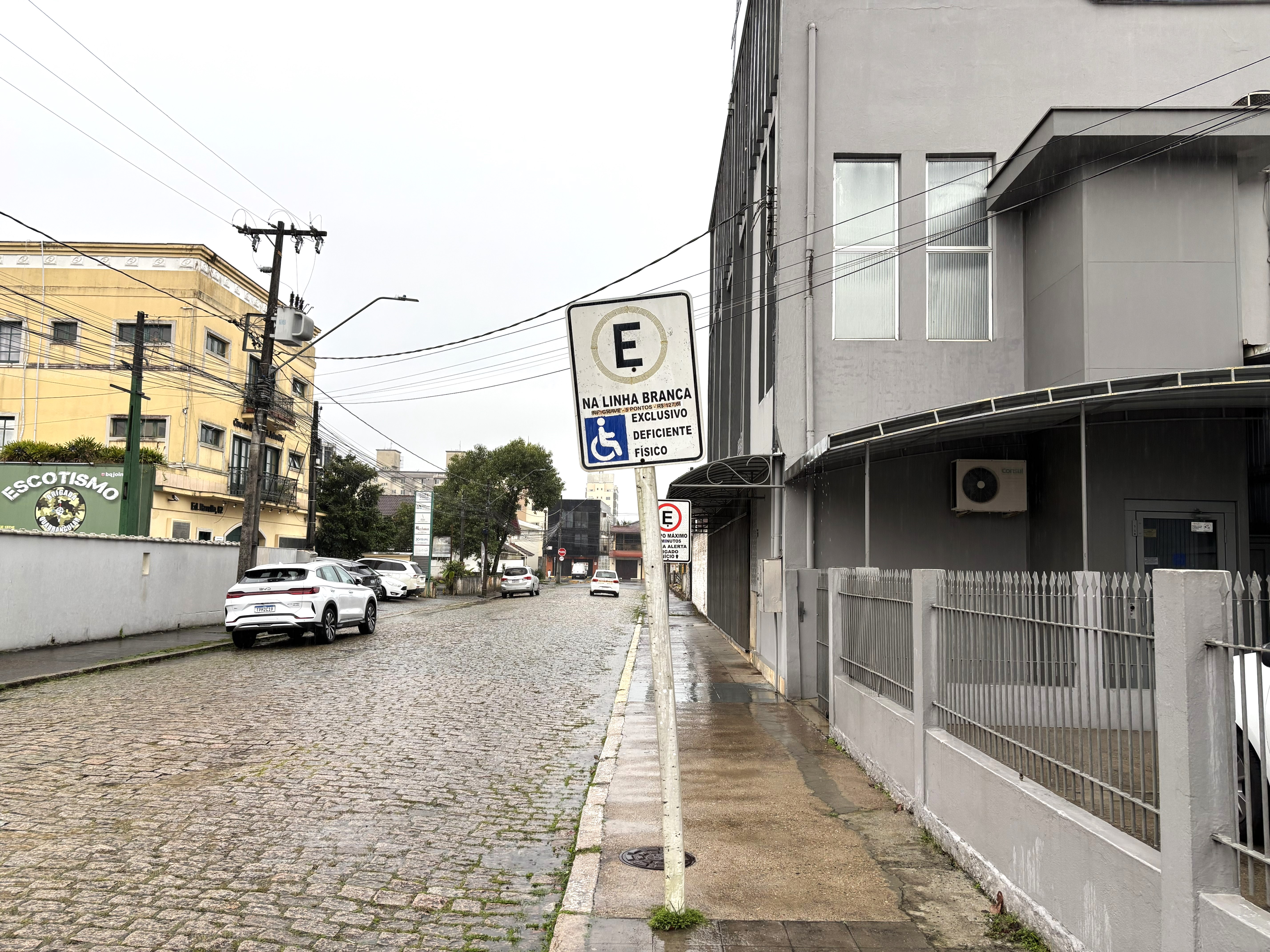 Placa de estacionamento exclusivo para deficiente físico na calçada em frente ao templo